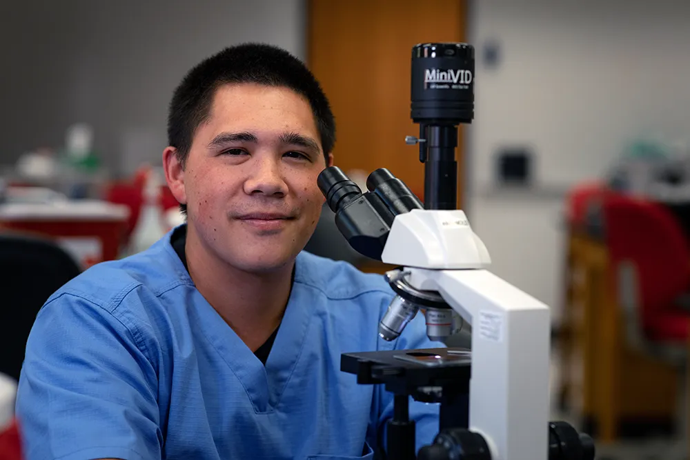 Student in lab with microscope